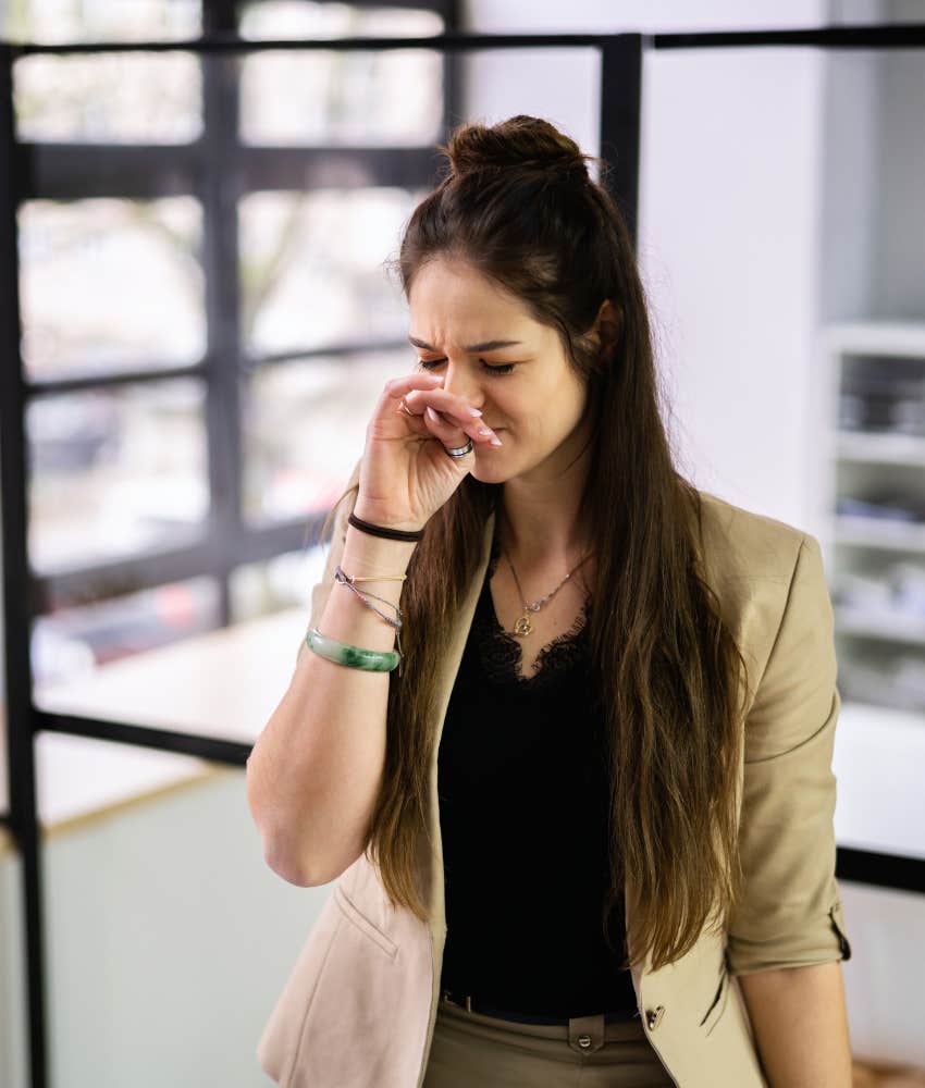 female employee smelling something foul in office