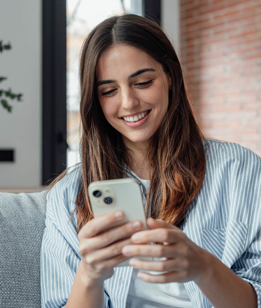 Woman smiling at a text from her boyfriend