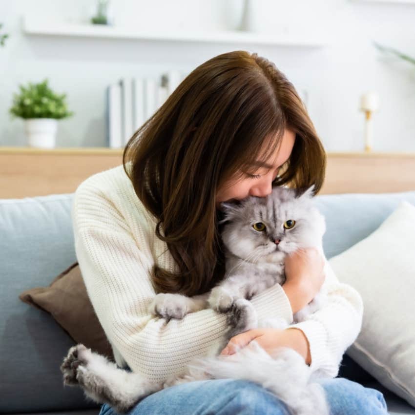 woman snuggling with cat