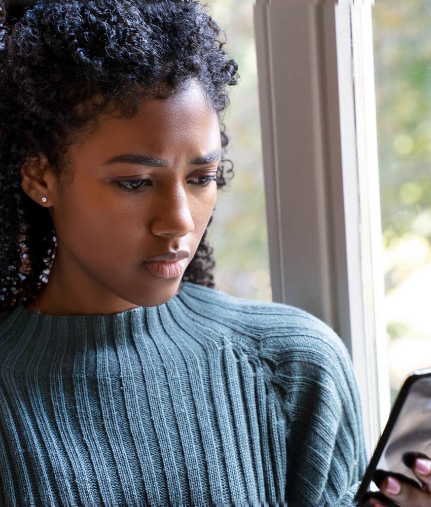 woman staring intently at cell phone