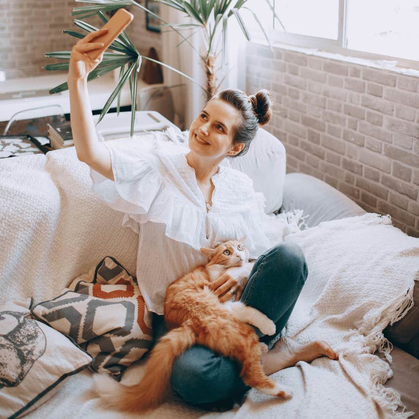 woman taking selfie with cat