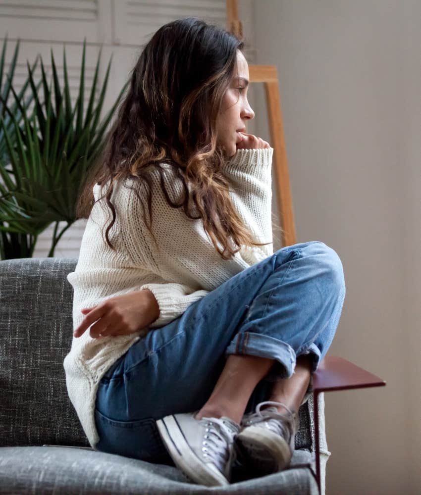 Woman curled up in chair feeling sad