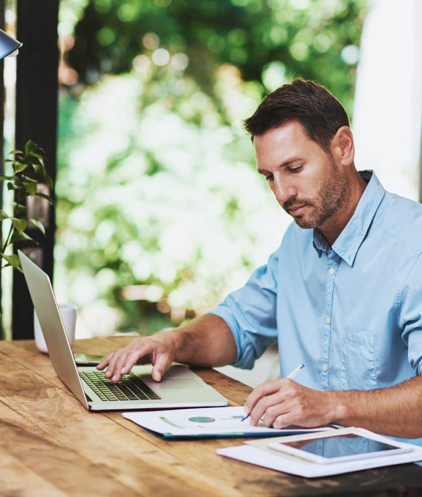 man working hard at desk on his laptop