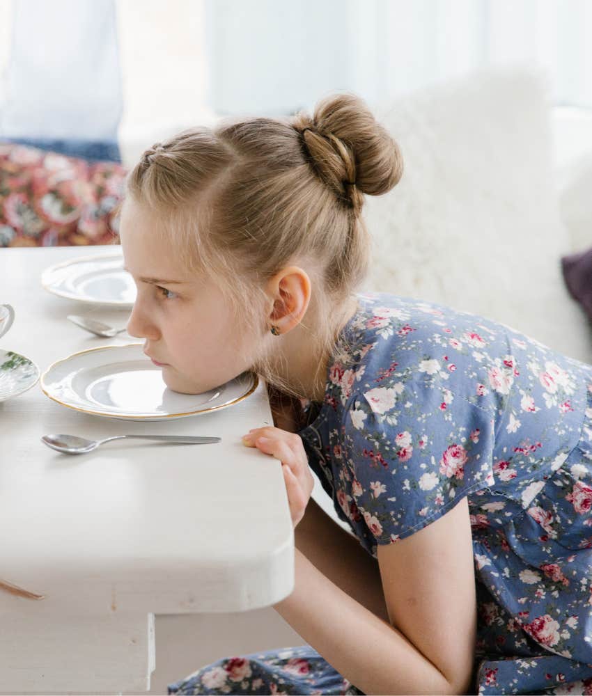 little girl with face on table waiting to eat