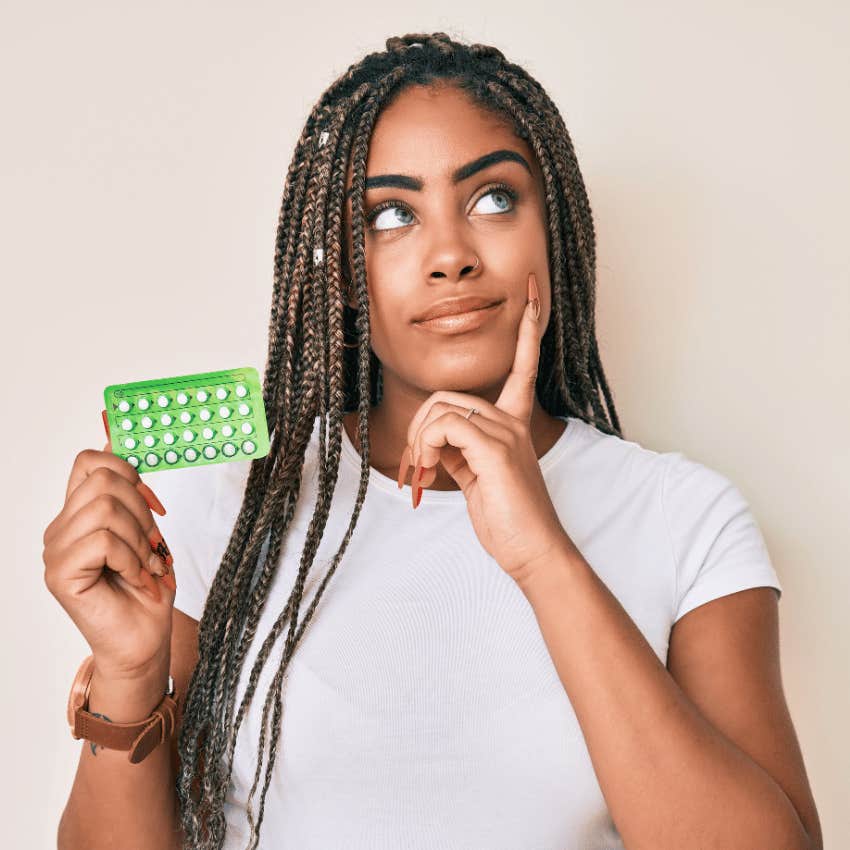 young woman holding contraception