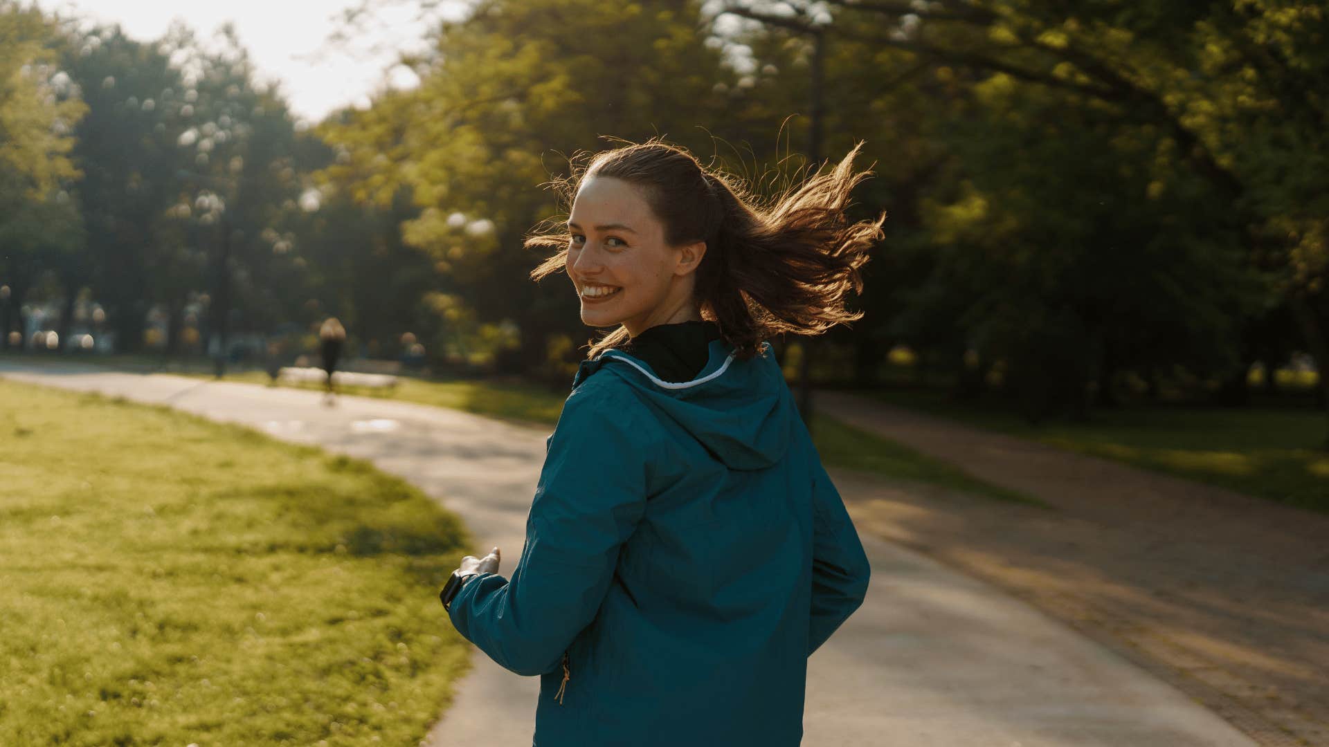 smiling young woman looking back while running