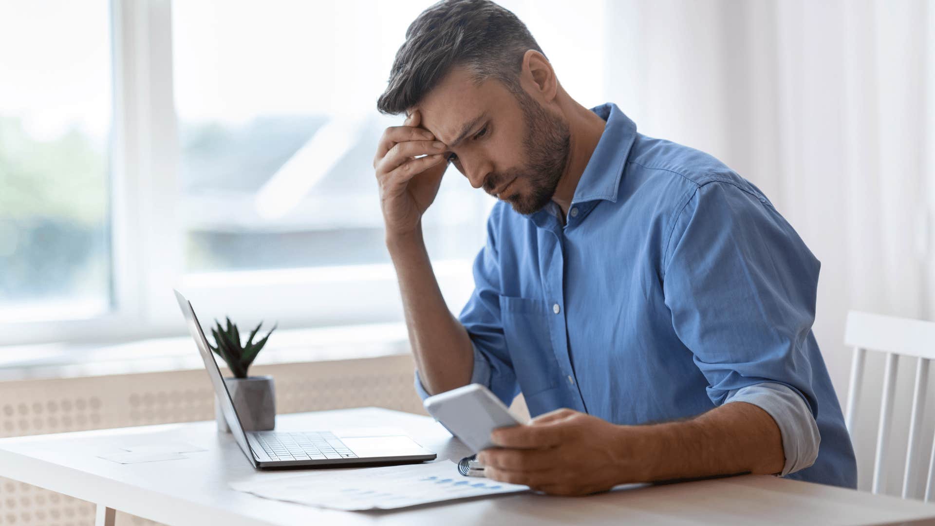 thoughtful freelancer looking at a phone