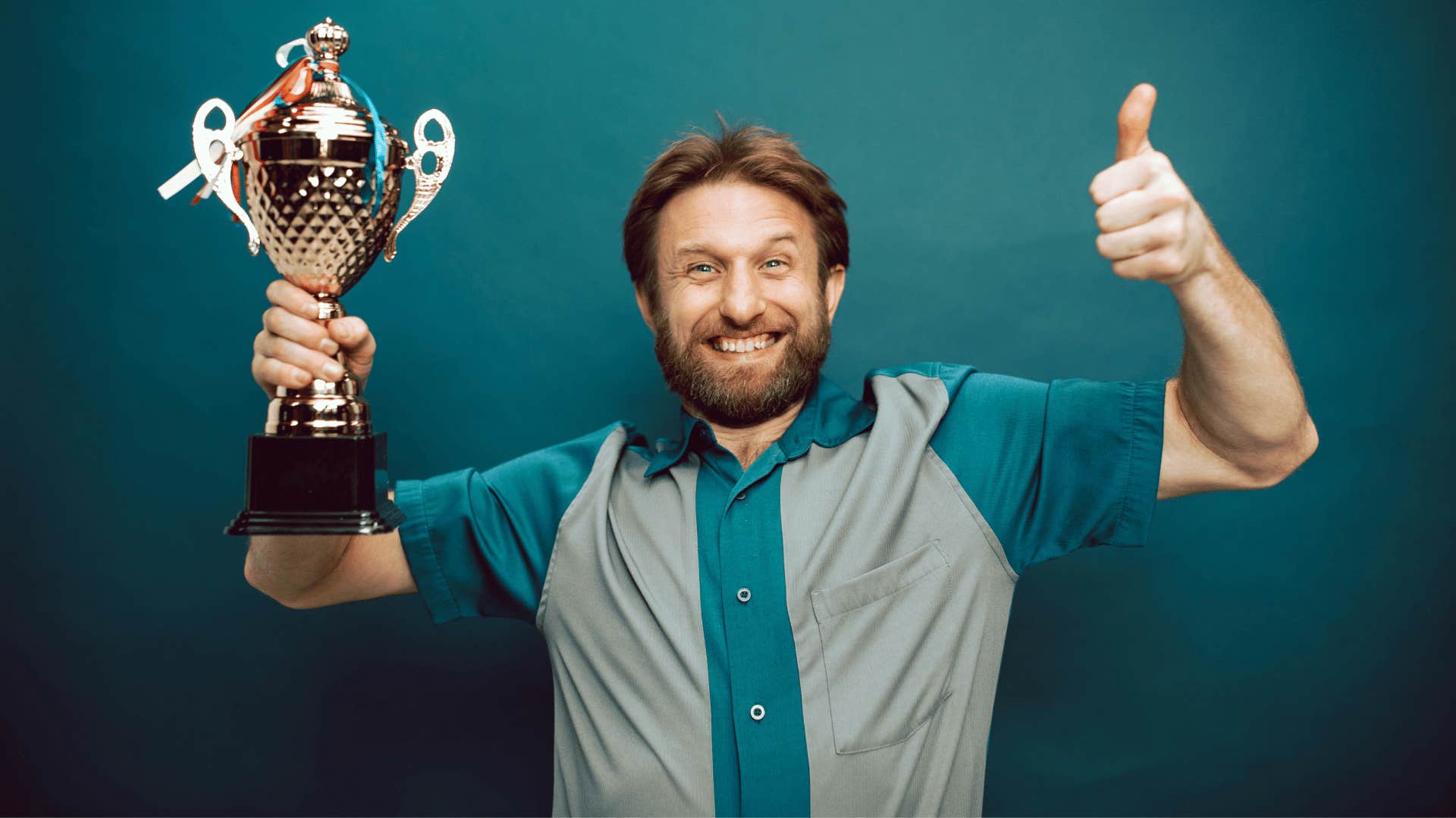 excited man holding up a trophy