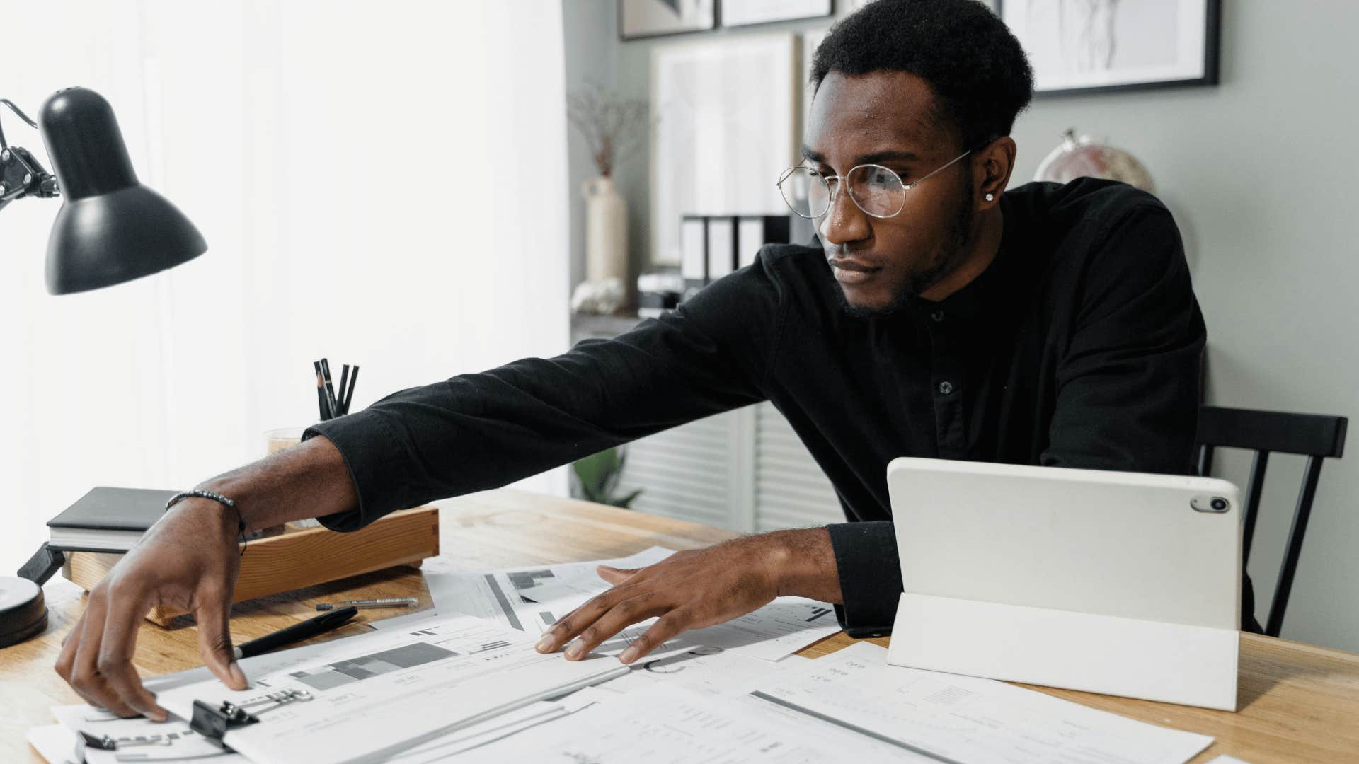 professional man rearranging packets of paper on desk