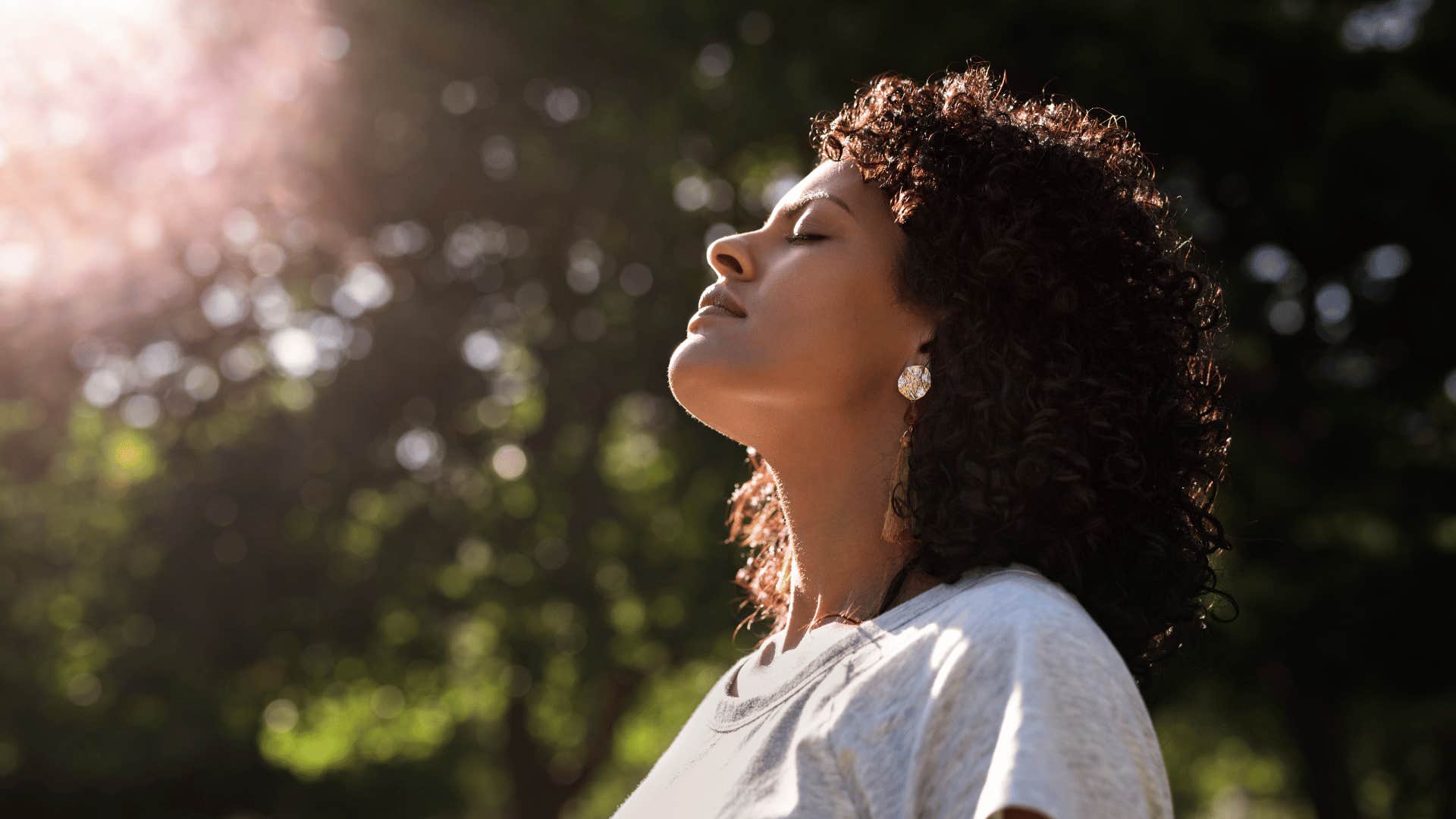 woman tilting her head up to sun