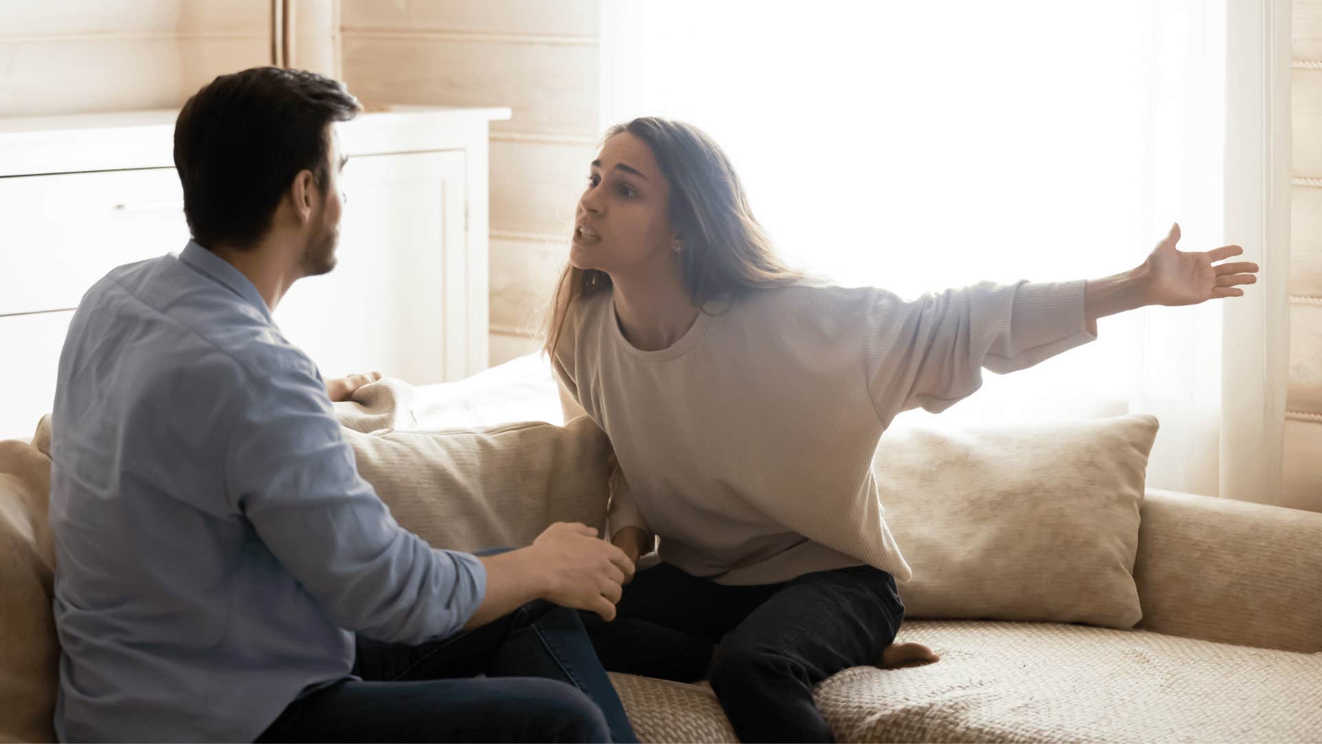 woman yelling at man on couch