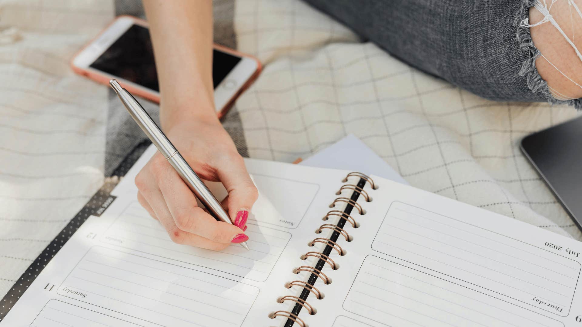 woman's hand writing in a planner