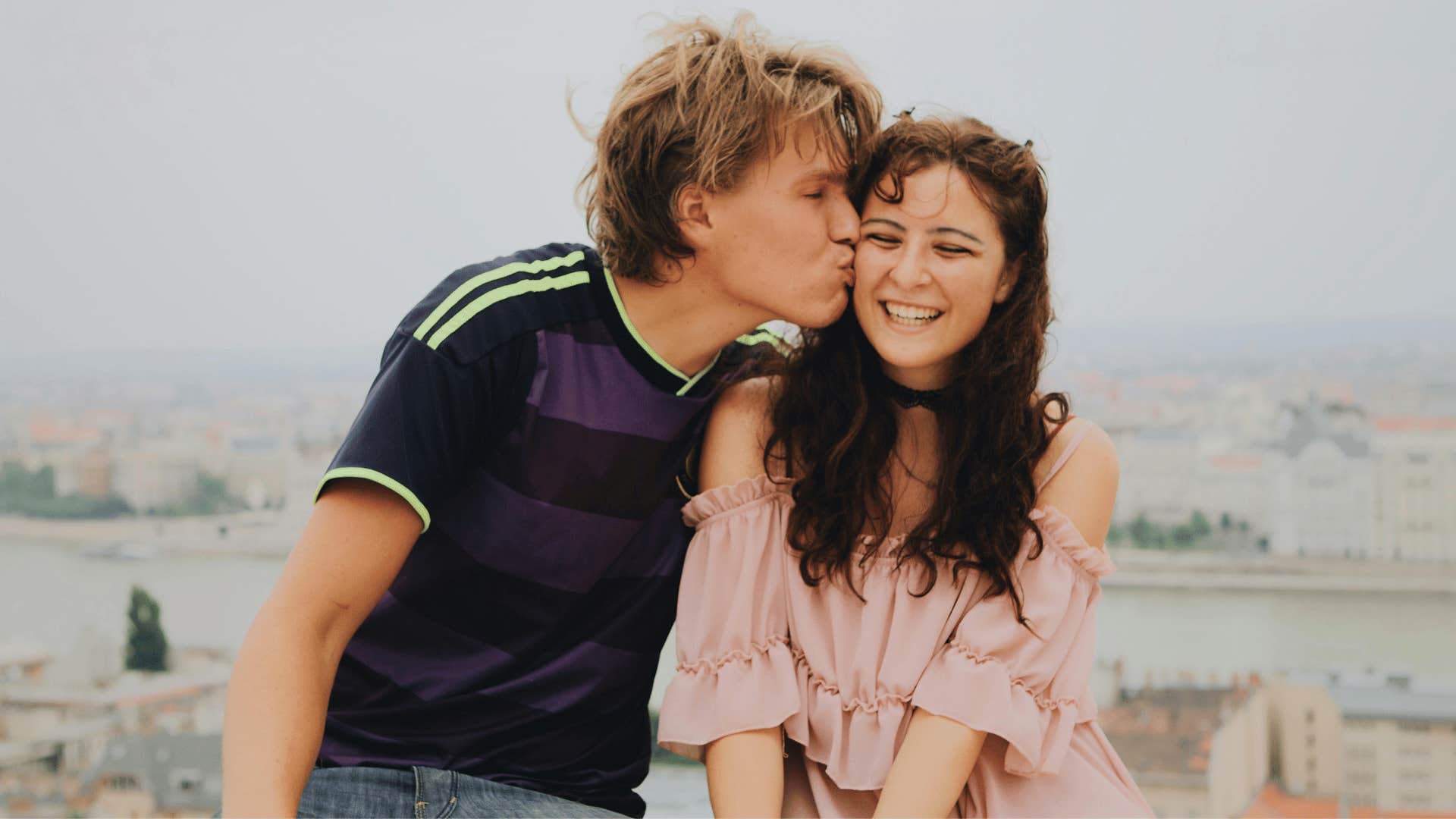 young man kissing the cheeky of a giddy young woman