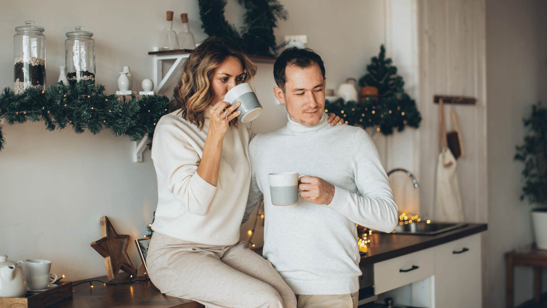 couple hugging and drinking warm drinks