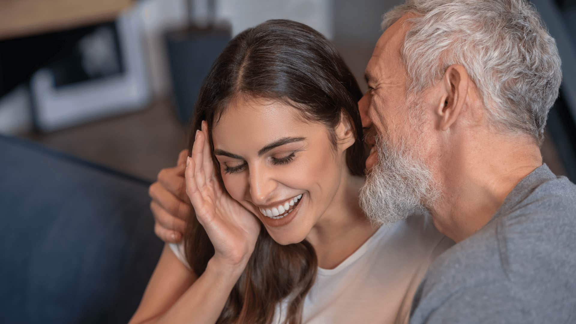 older gentleman whispering to smiling woman