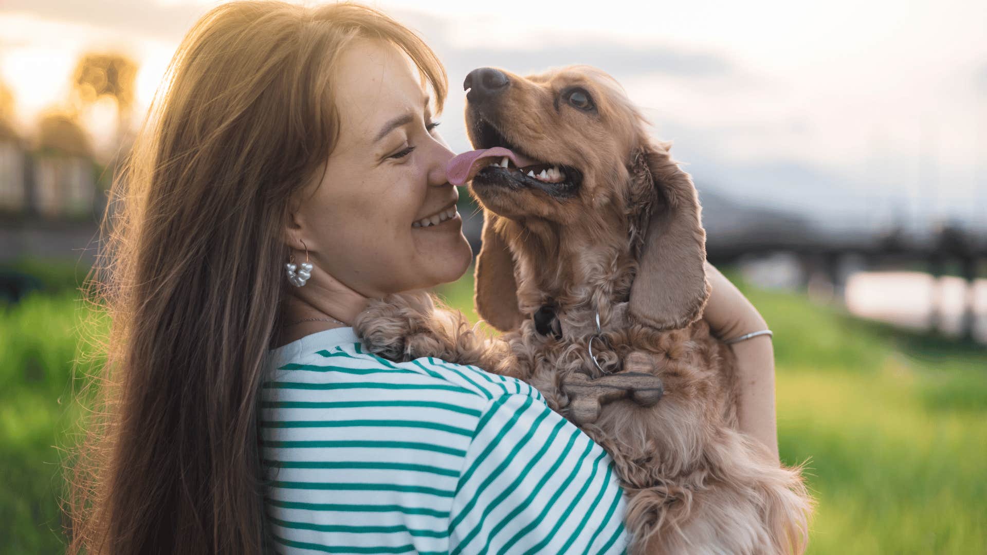 smiling woman holding a puppy