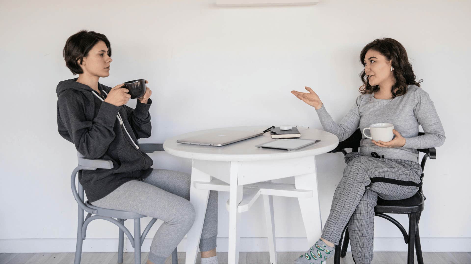 two young women talking at a table