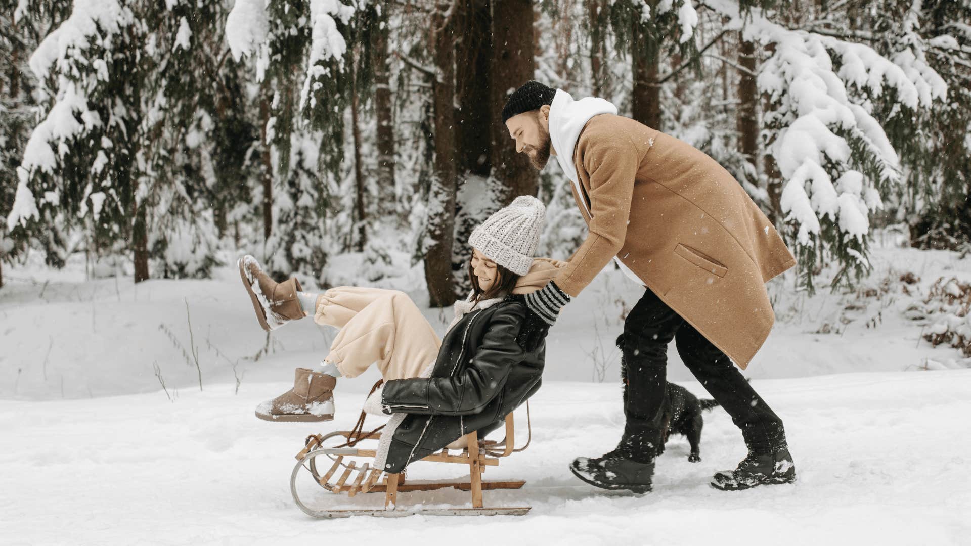 man pushing a woman in a sled