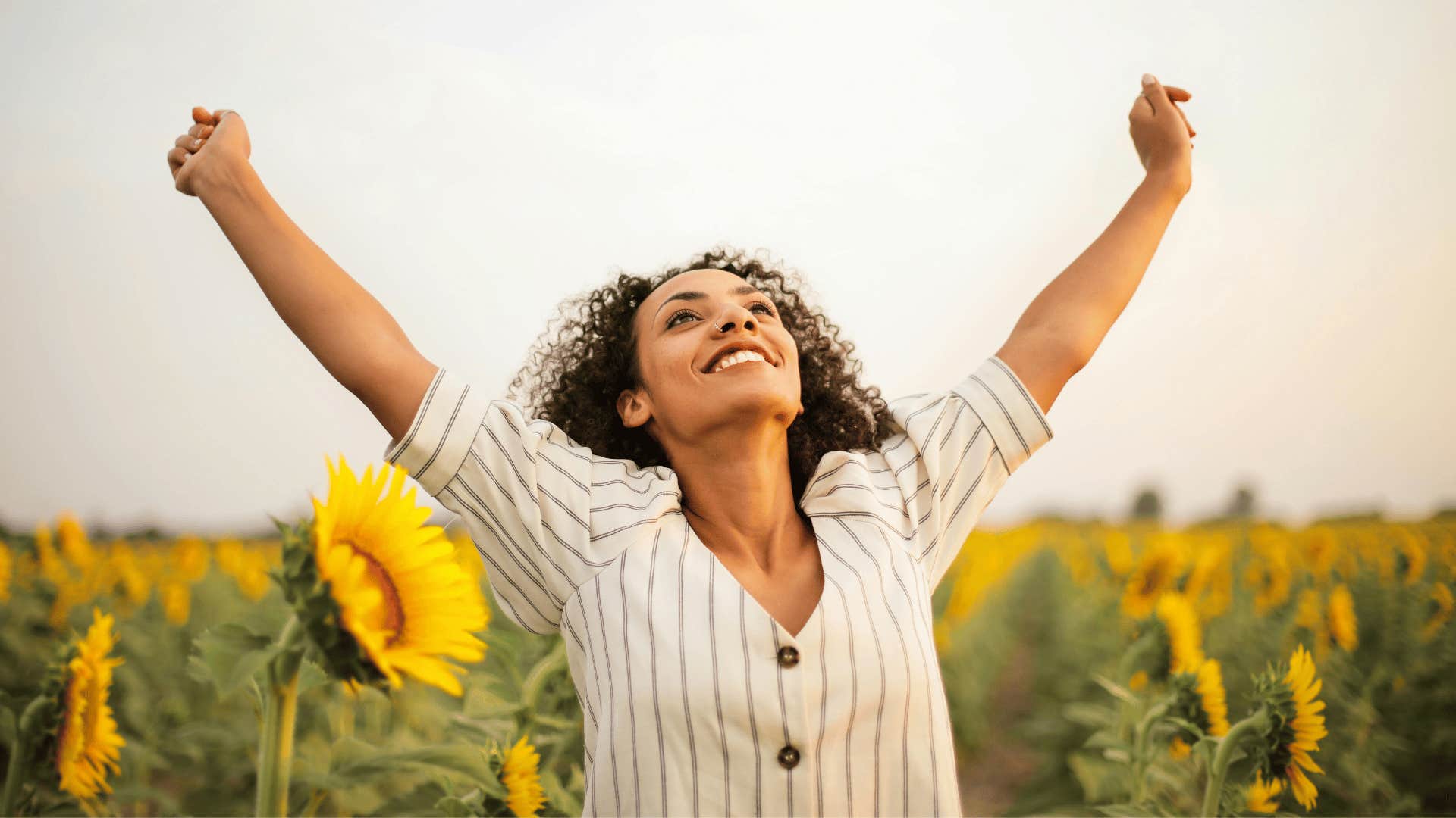 happy woman standing in a sunflower field