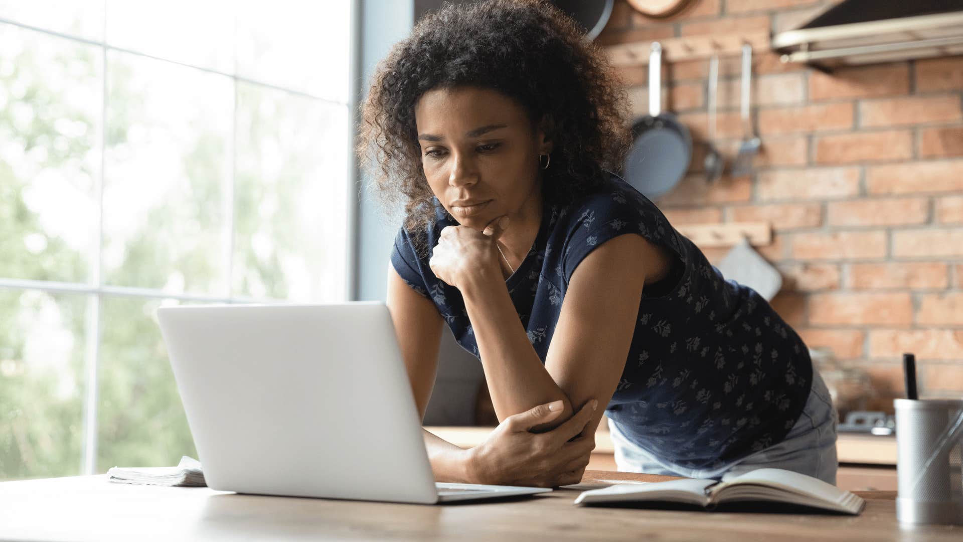 thoughtful woman looking at a laptop screen