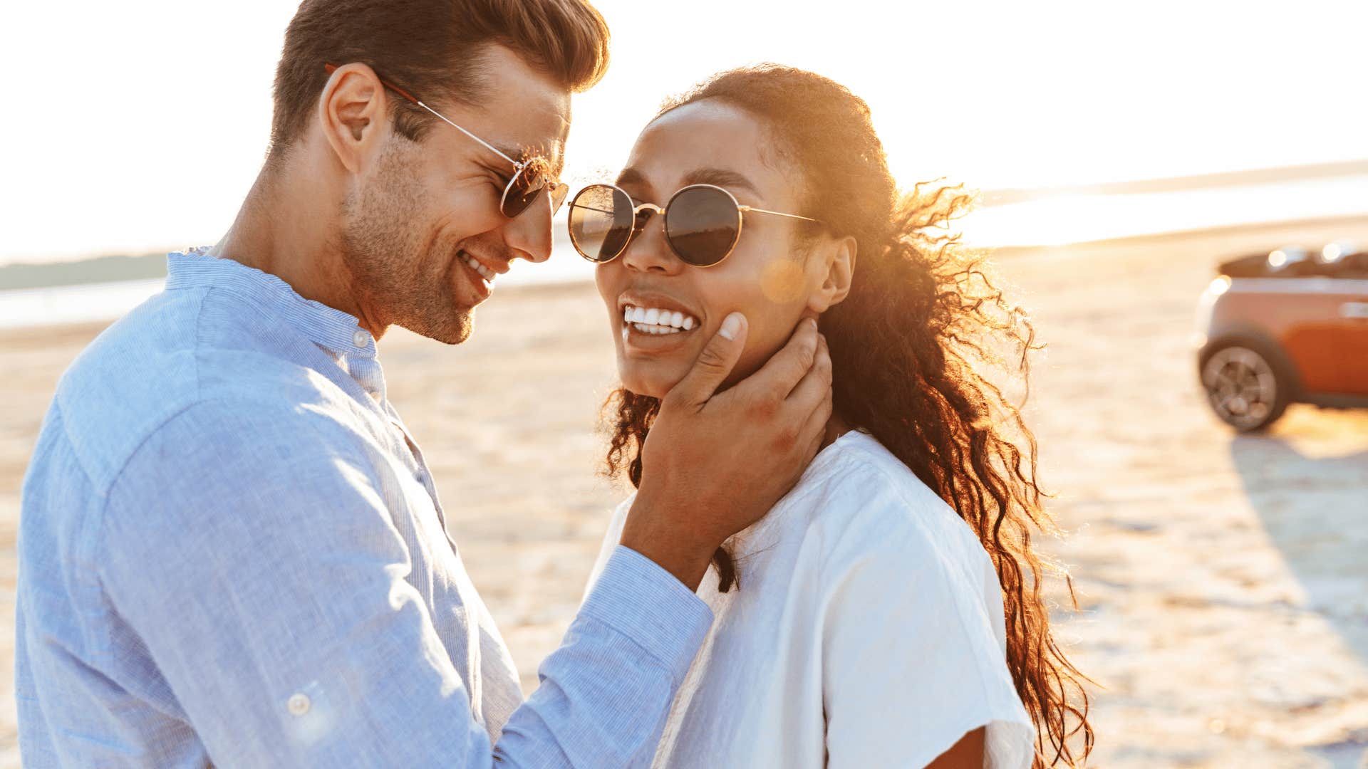 happy couple standing close together on the beach