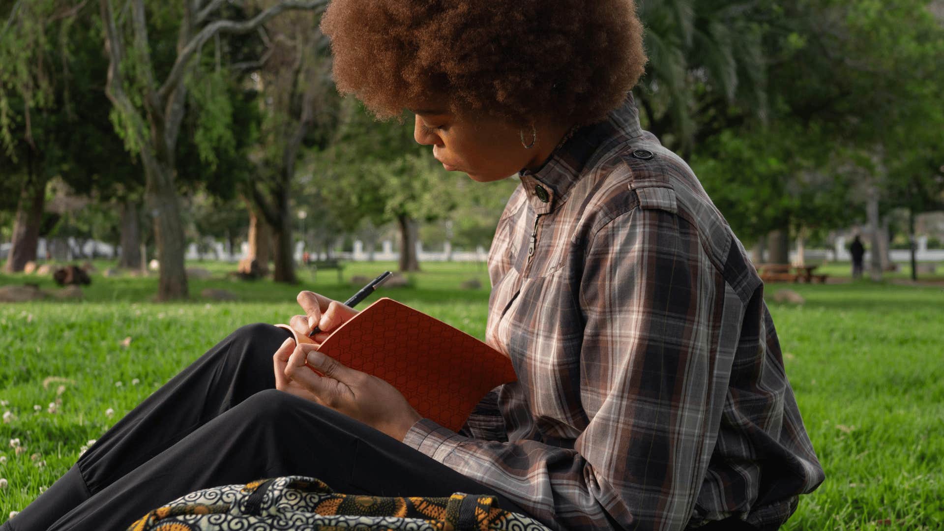 young woman journaling outdoors