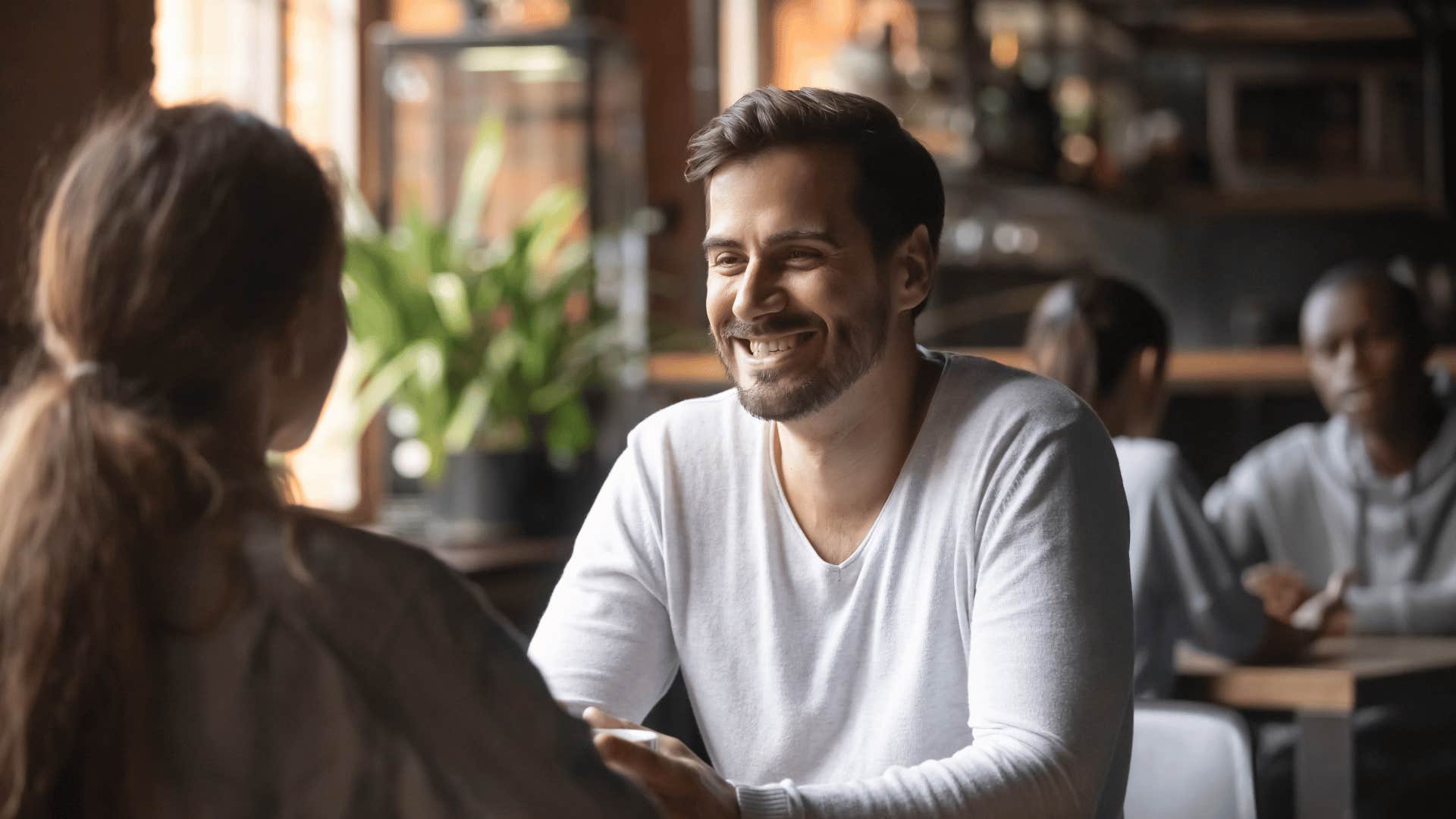 happy man talking to woman at a cafe