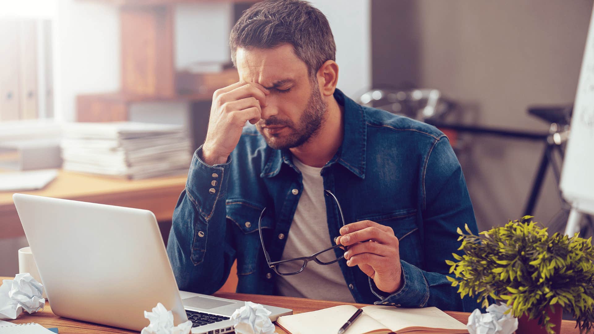 stressed young man pinching the bridge of his nose