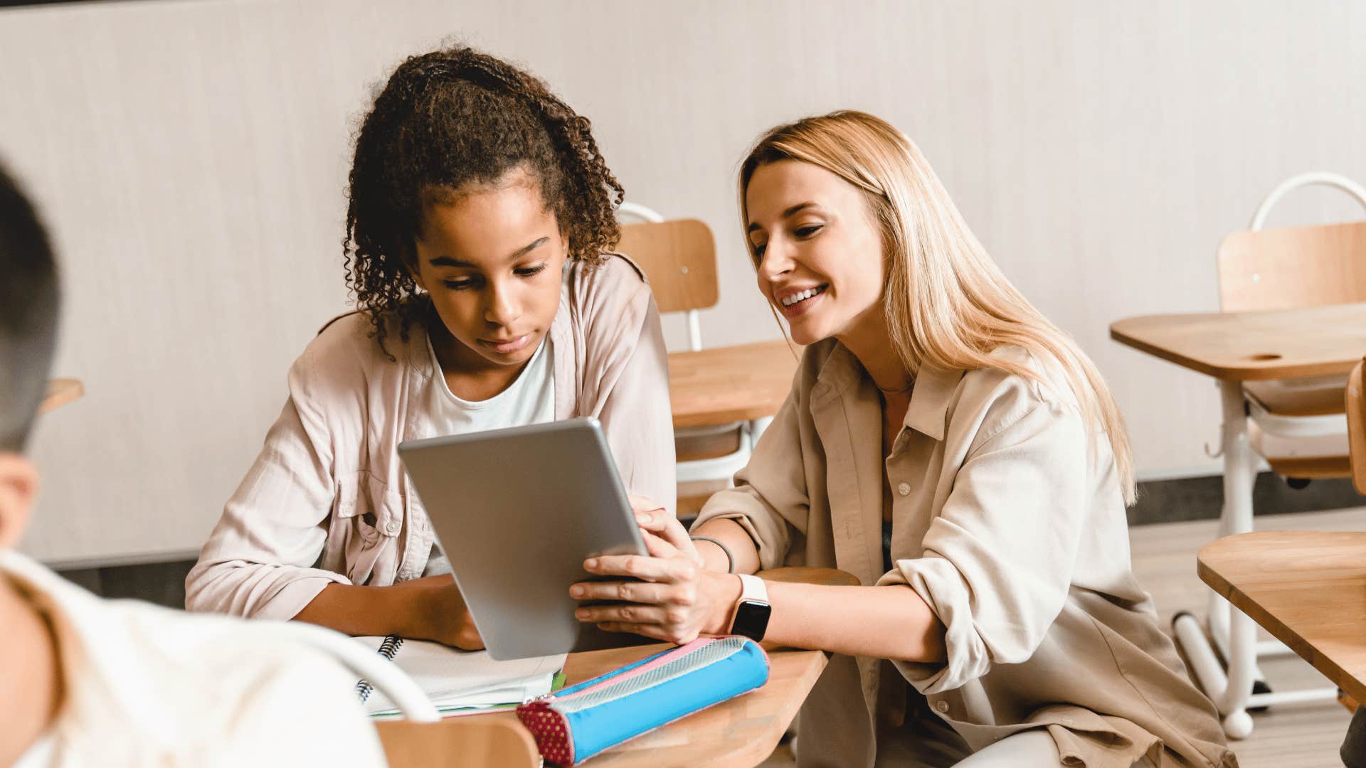 young teacher helping a young student