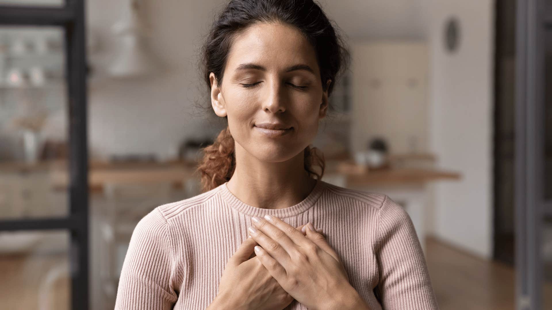 woman closing her eyes in gratitude