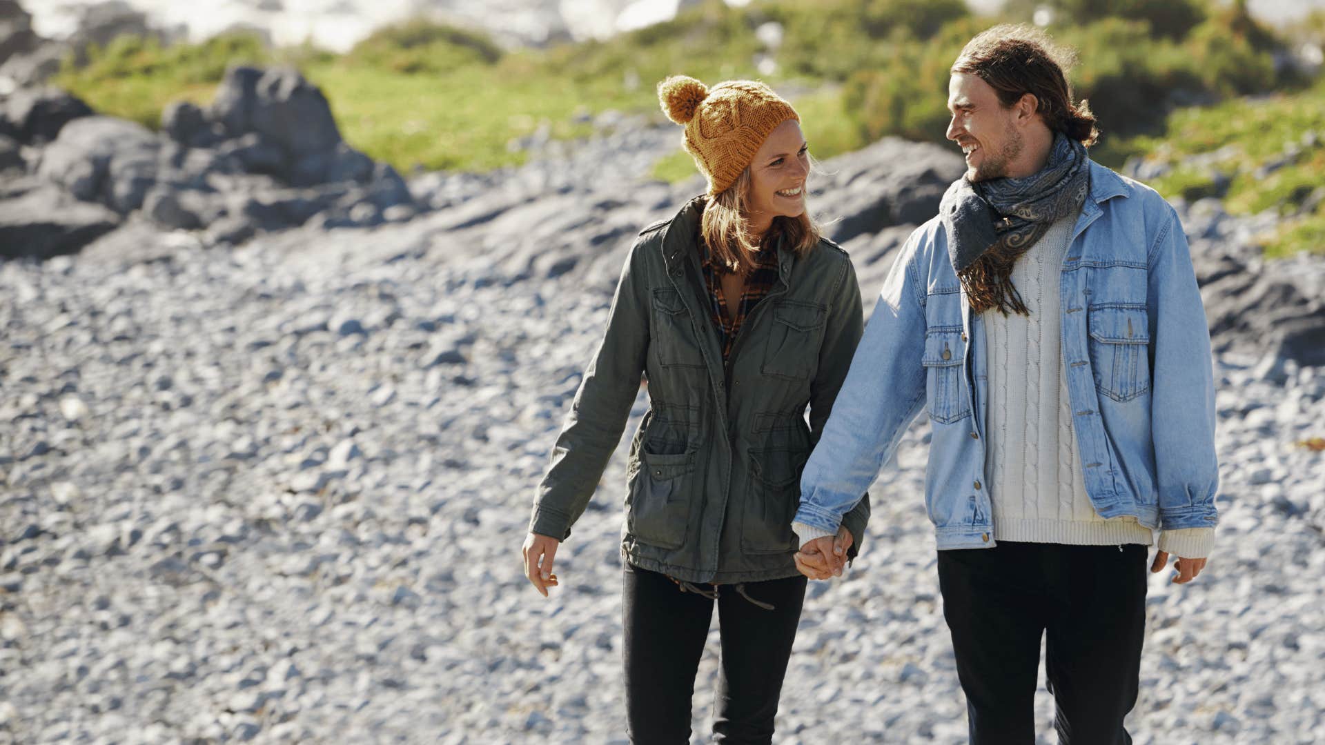 happy couple walking down a beach