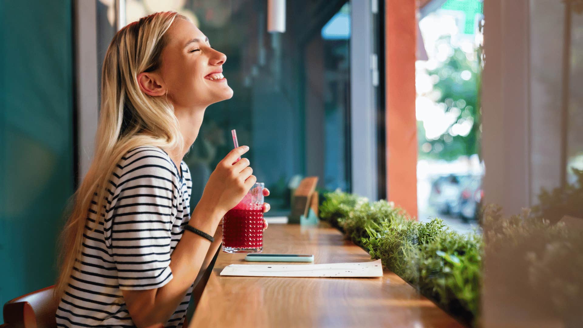 happy woman drinking a cup of pressed juice