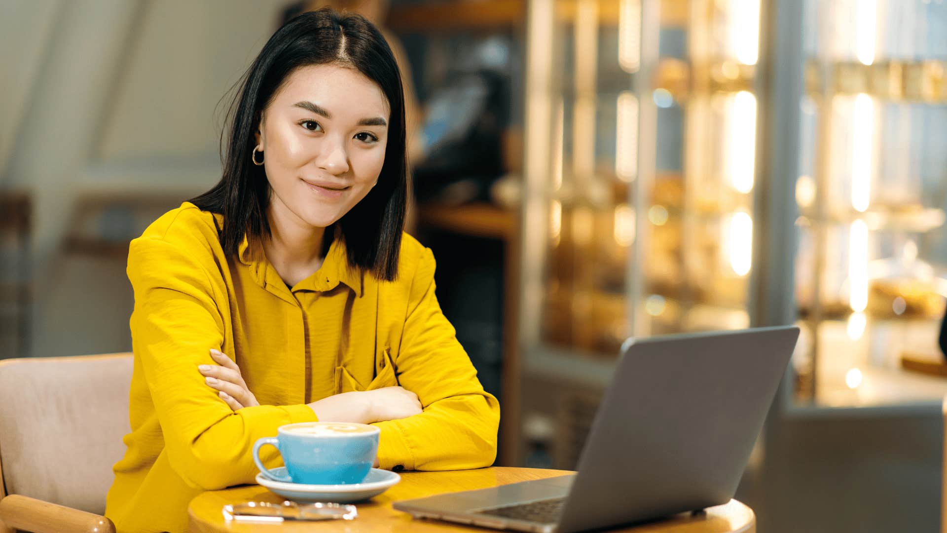 smiling woman in a cafe with an open laptop