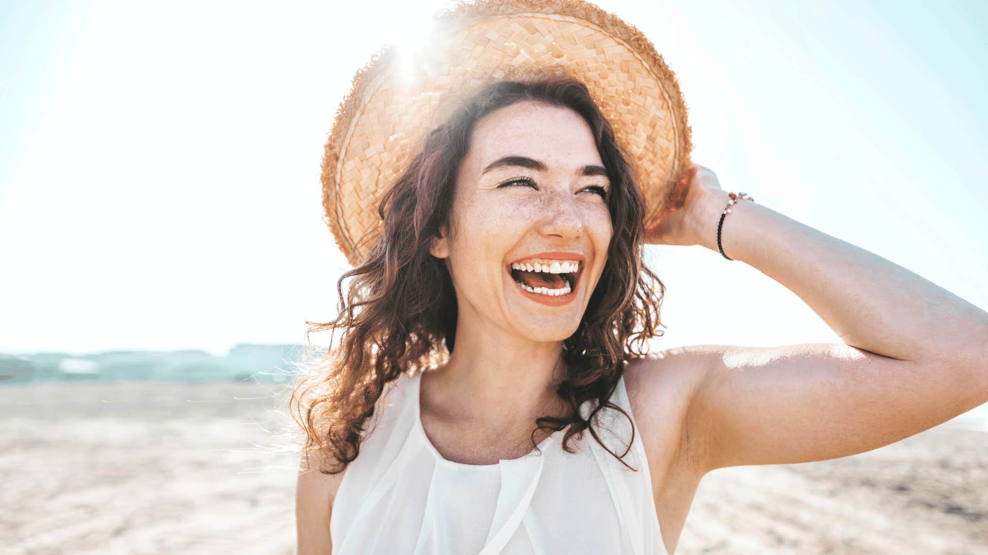 smiling young woman with freckles at beach