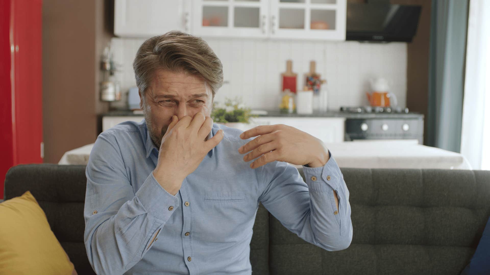 man covering his nose in disgust