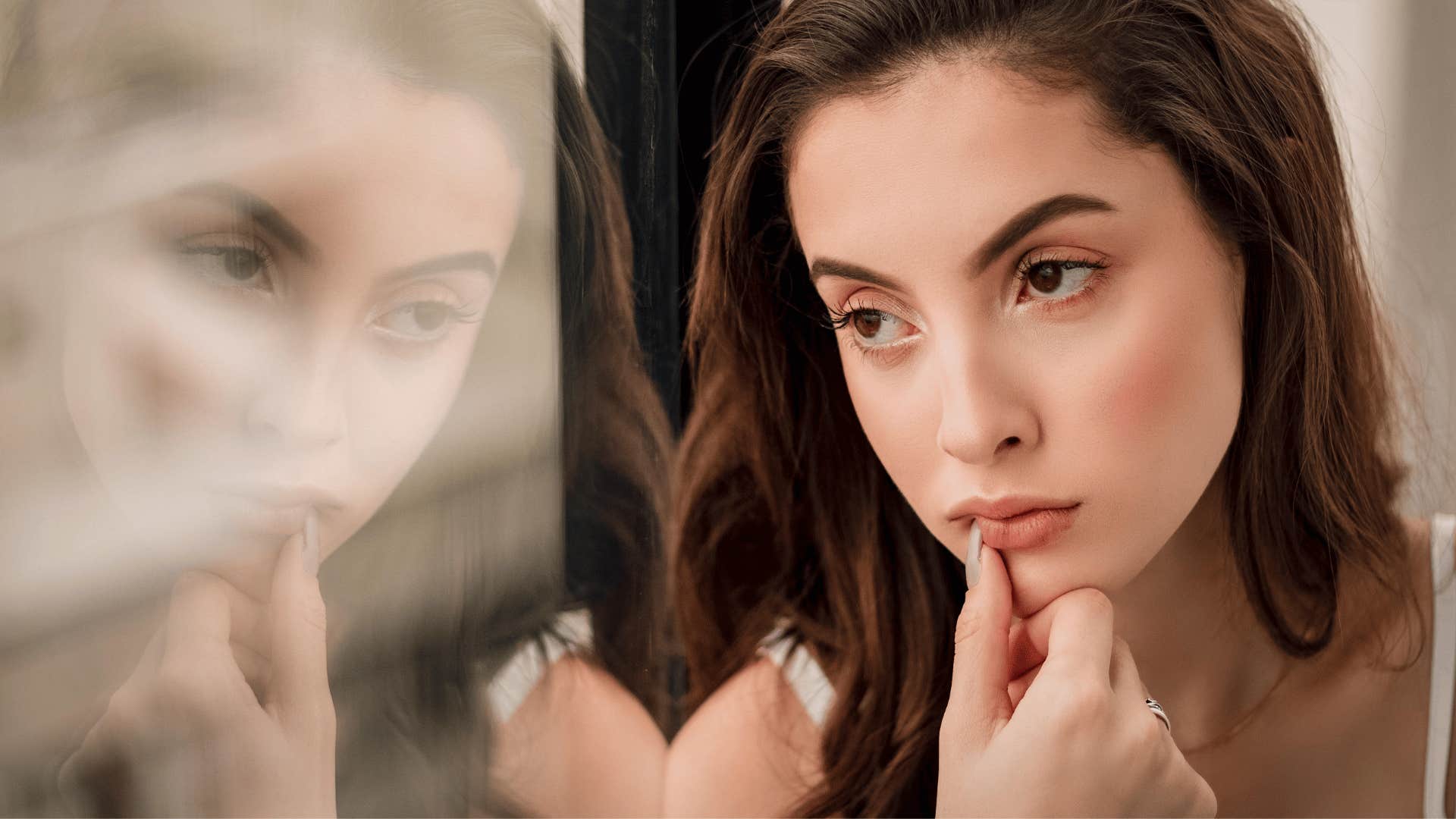 pensive young woman looking out of window