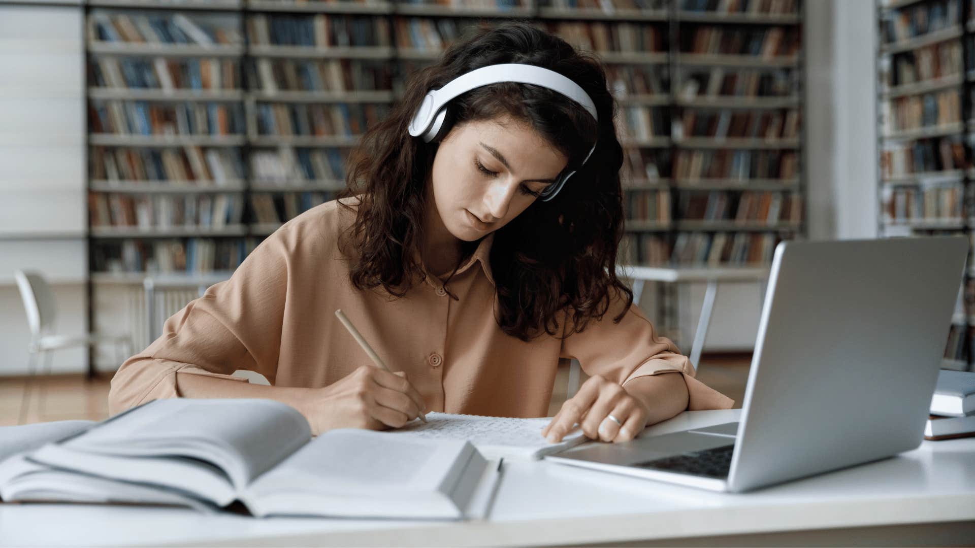 young woman wearing headphones focused on her work