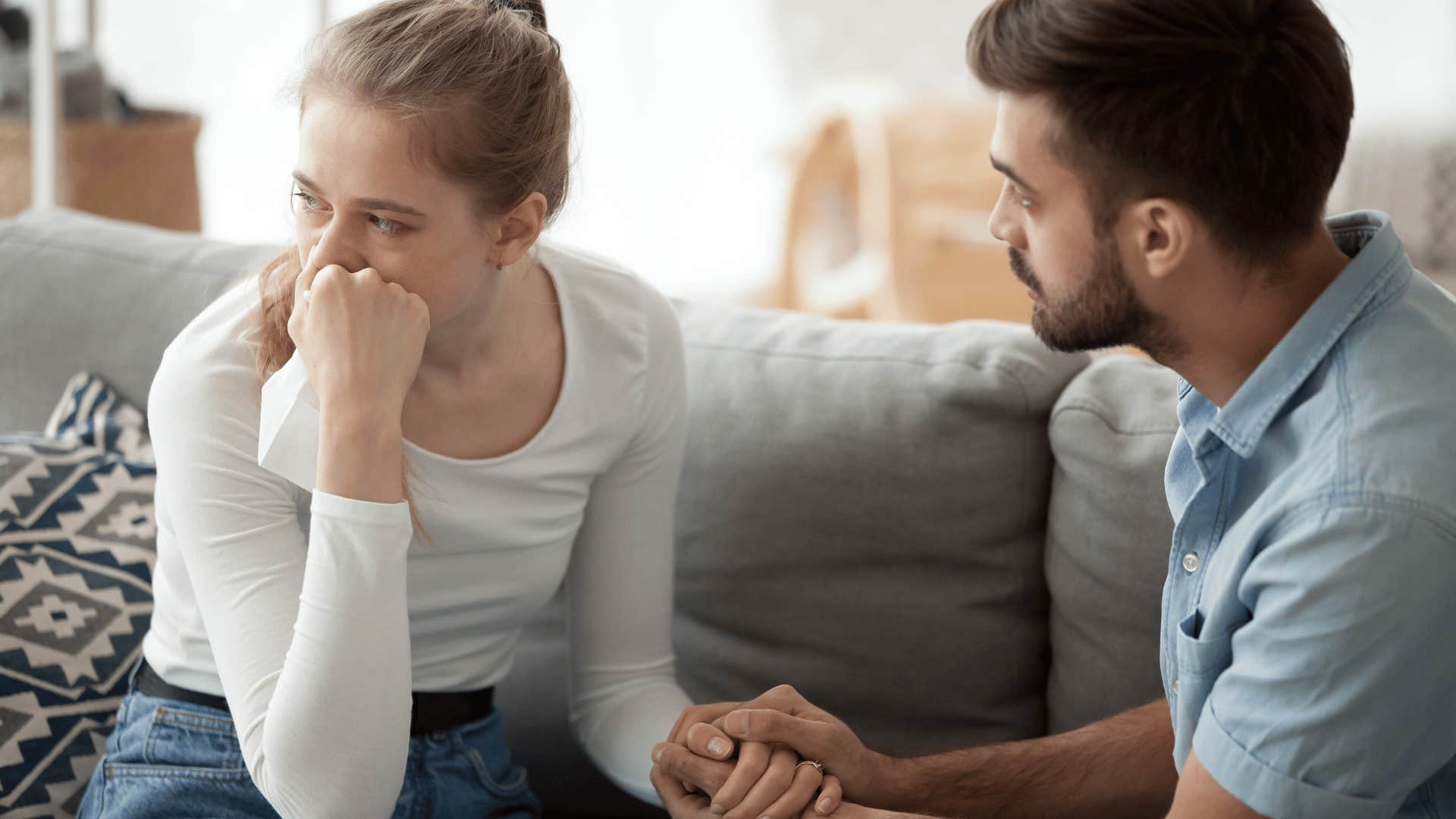 man comforting a teary woman