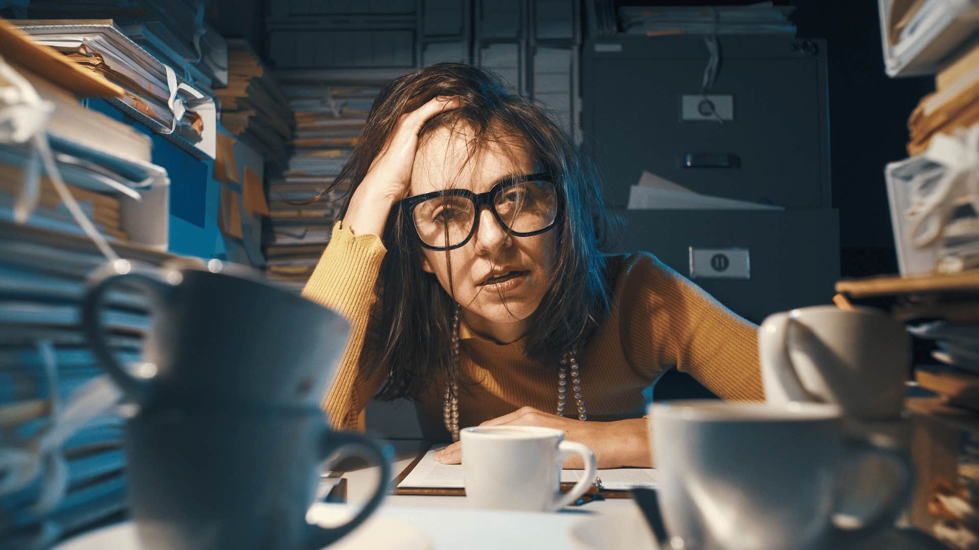 stressed woman surrounded by several coffee cups