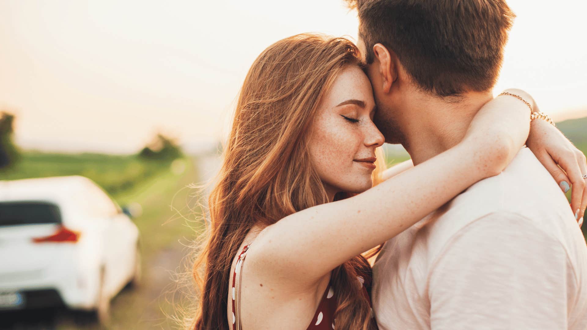 young woman with freckles hugging a man