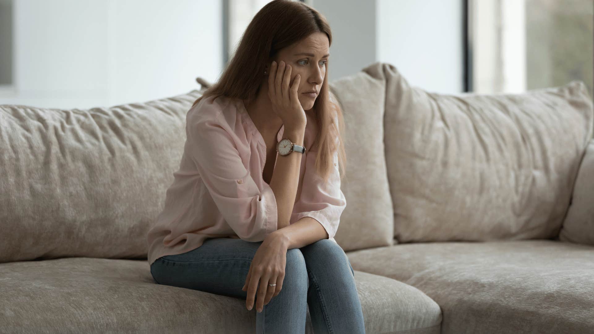 sad woman sitting on a sofa