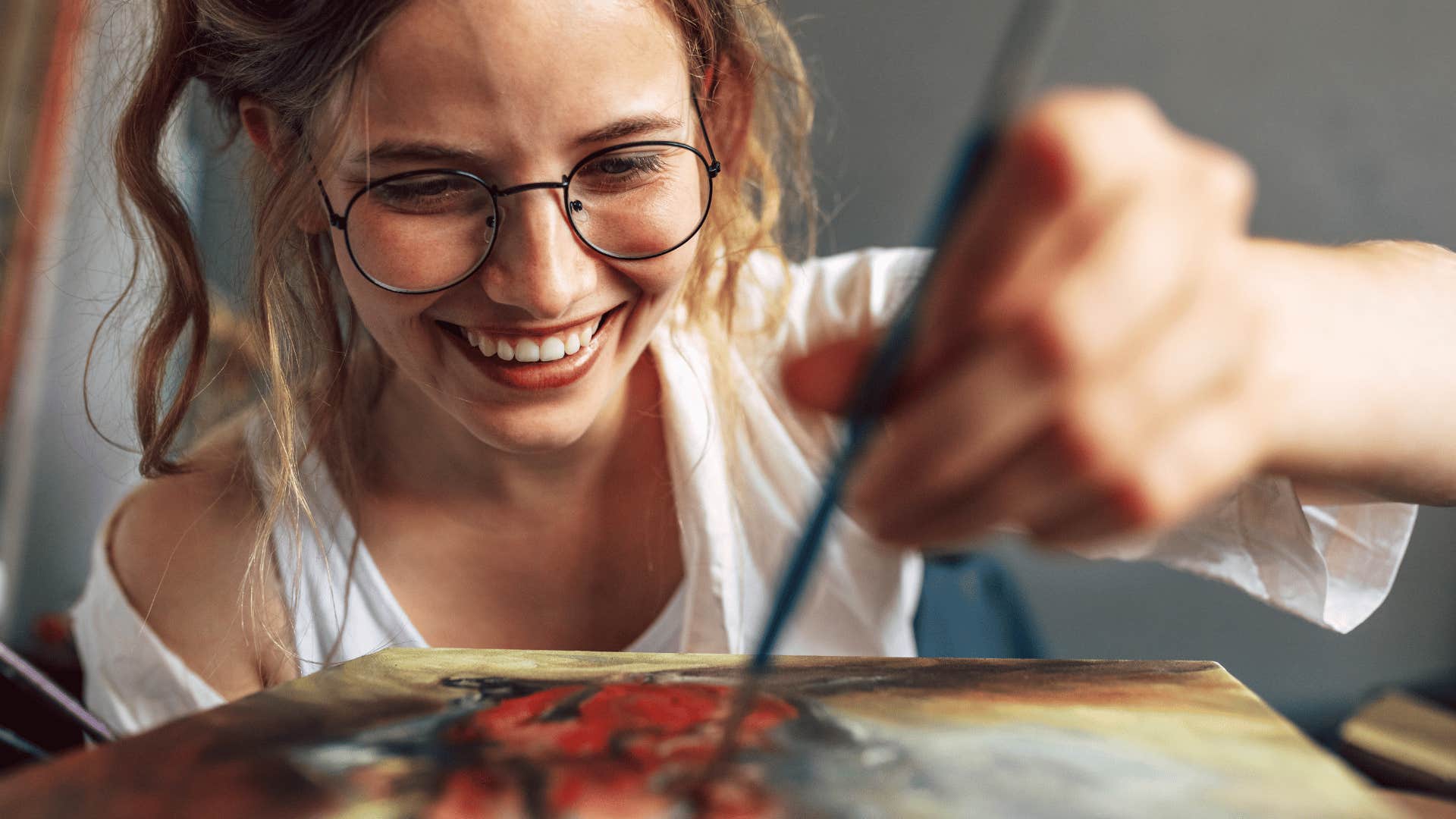 young woman painting on a canvas