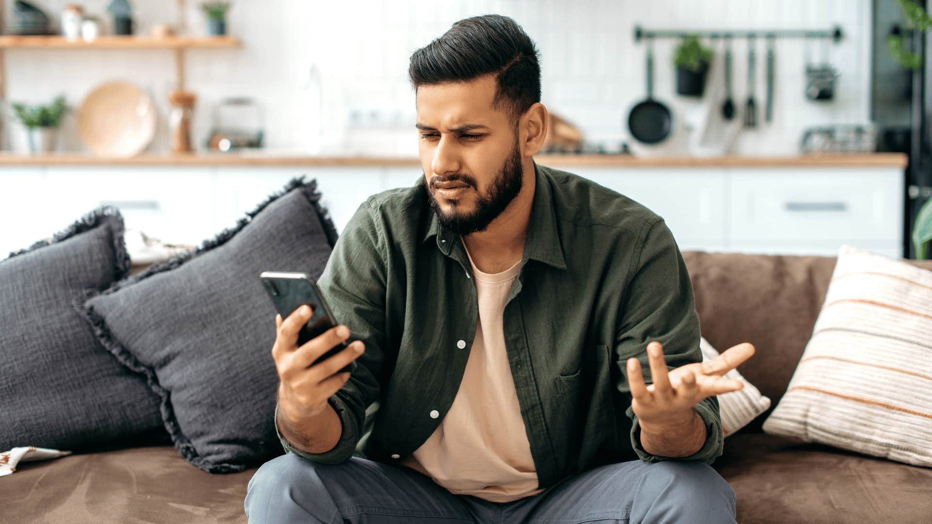 confused man looking at his phone