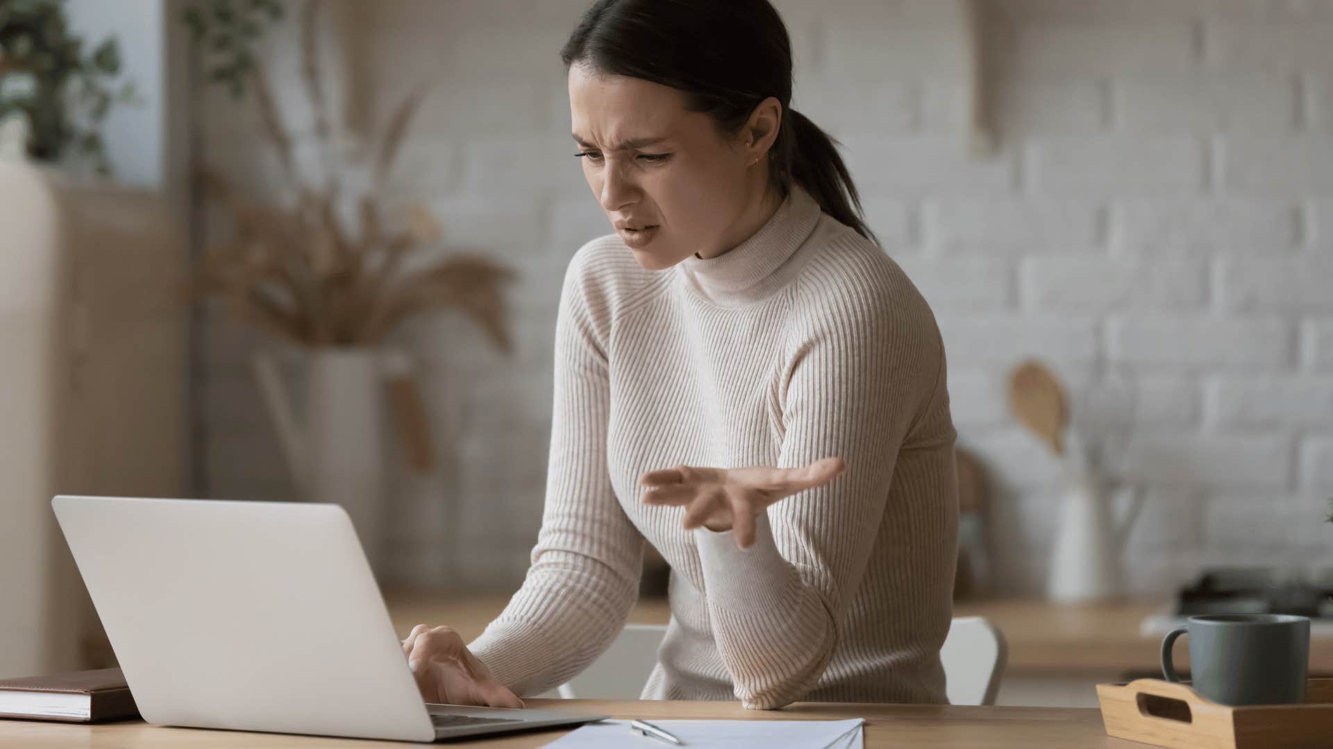 frustrated woman staring at an open laptop