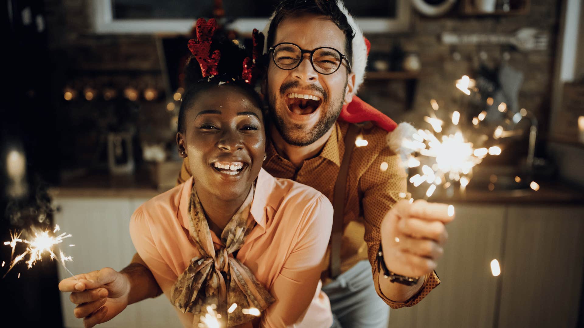 Laughing couple play with sparklers