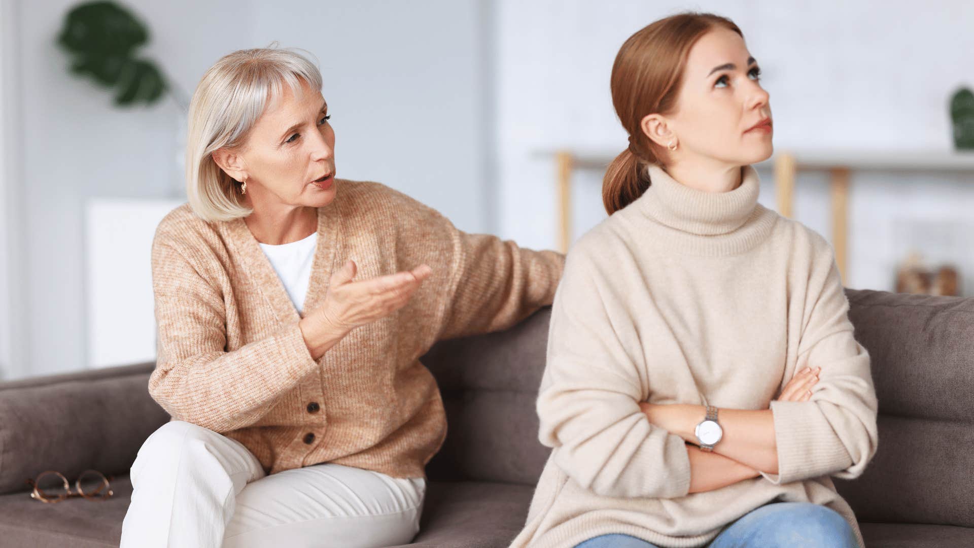 woman ignoring older woman while crossing arms 