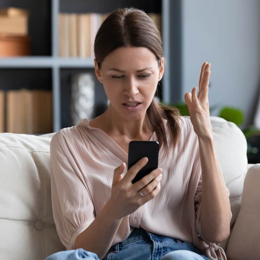 Airbnb host looking shocked looking at her cell phone. 