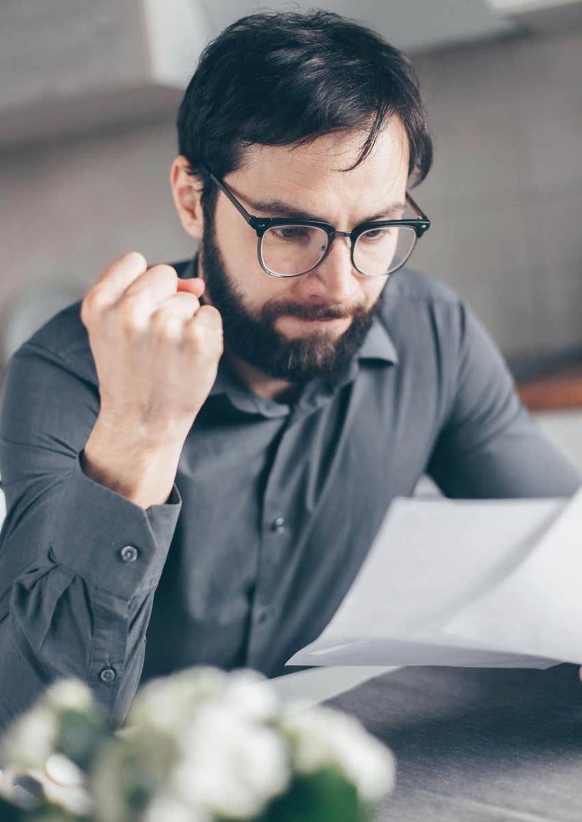 angry man looking at papers