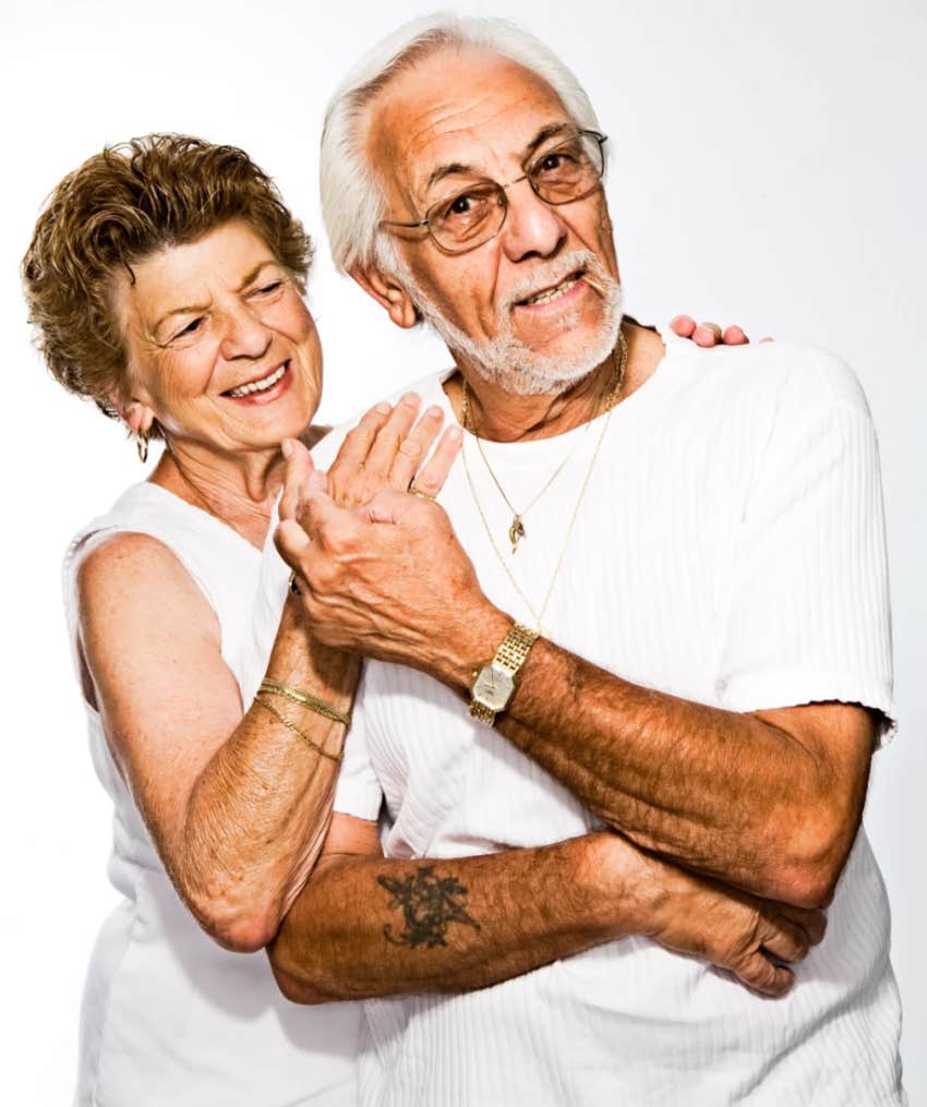 arm tattoo on older man who is standing with his wife