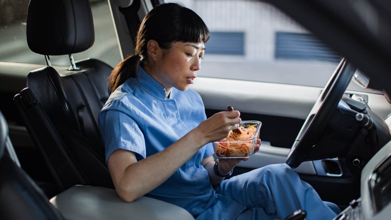 American worker eating by herself in her car during her lunch break